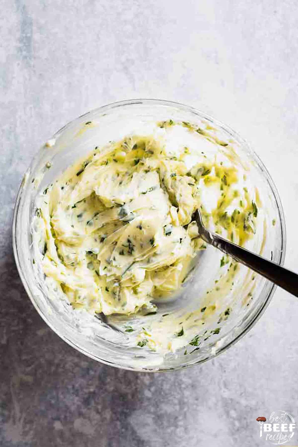 Stirring garlic butter for steaks in a bowl