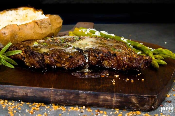 Close up of garlic butter dripping off of grilled rib eye steak