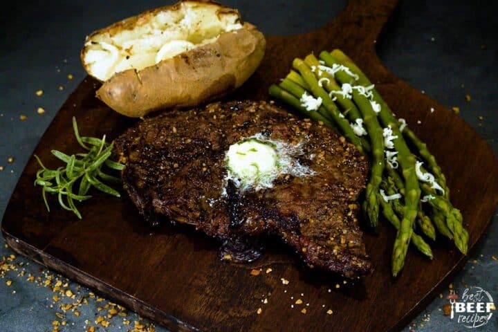 grilled ribeye with compound butter on a serving board