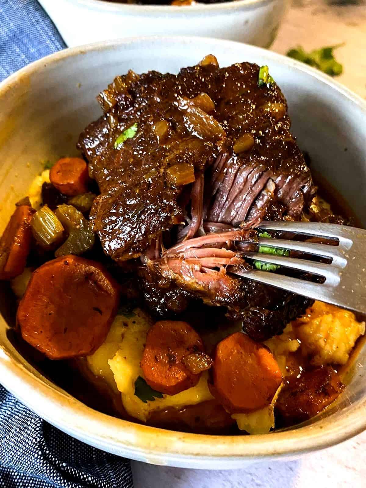 fork taking a piece out of slow cooker beef short ribs