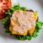 Burger sauce on top of a burger on a plate