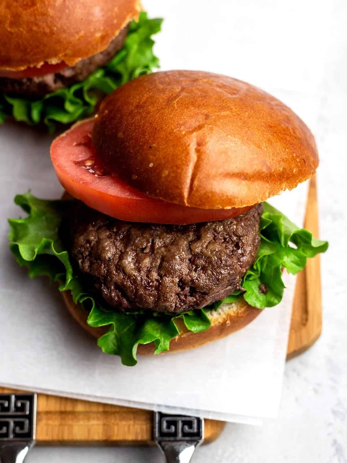 Burger with a bun, lettuce and tomato.