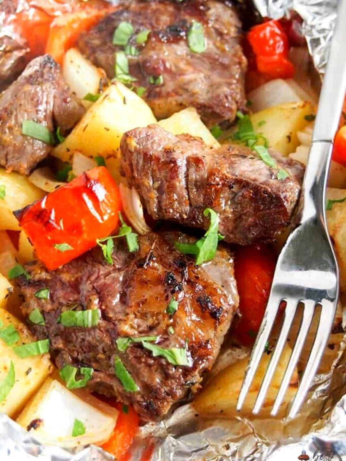 Steak in foil with peppers and potatoes.