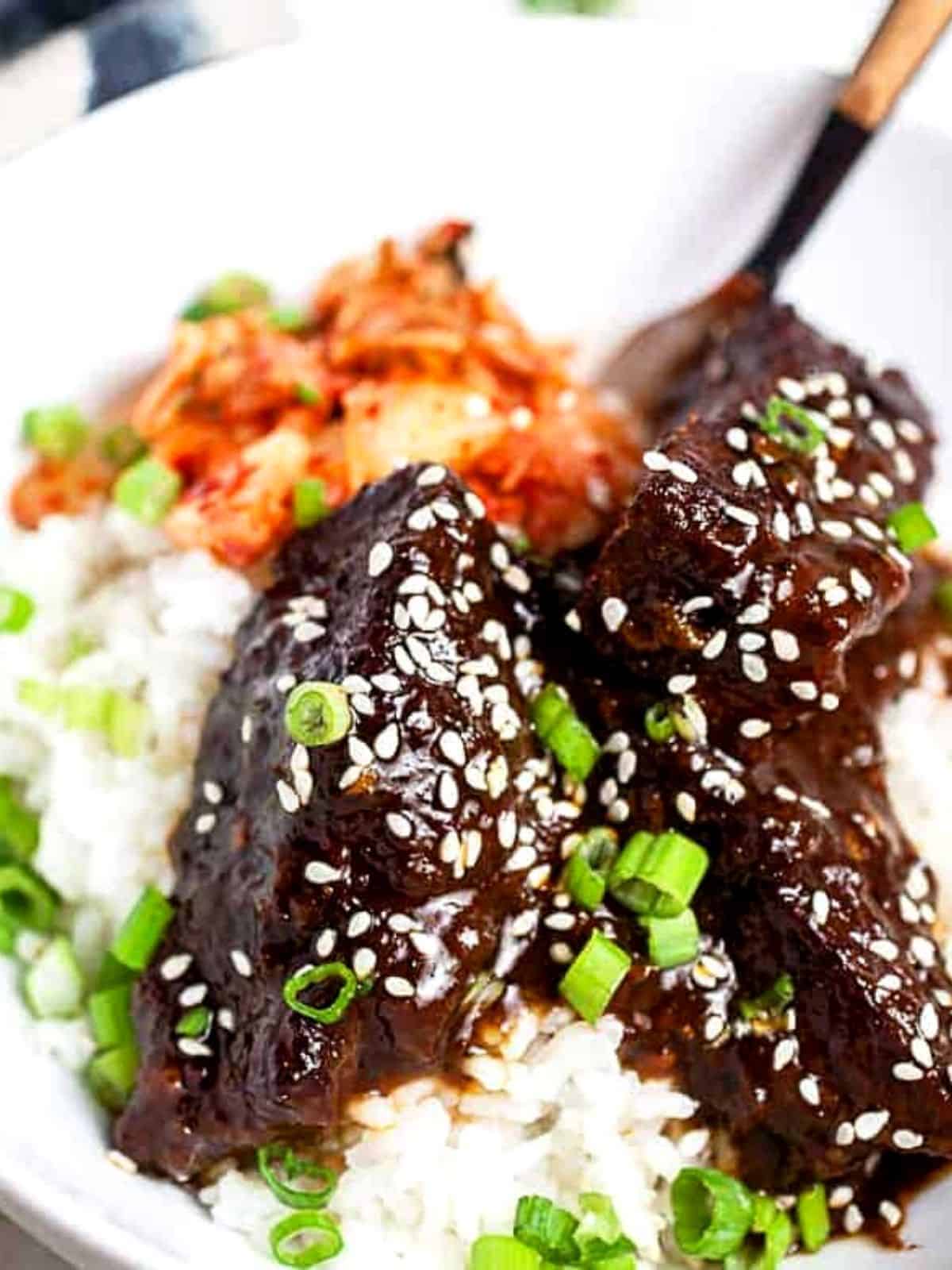 Short ribs served over white rice with sesame seeds.