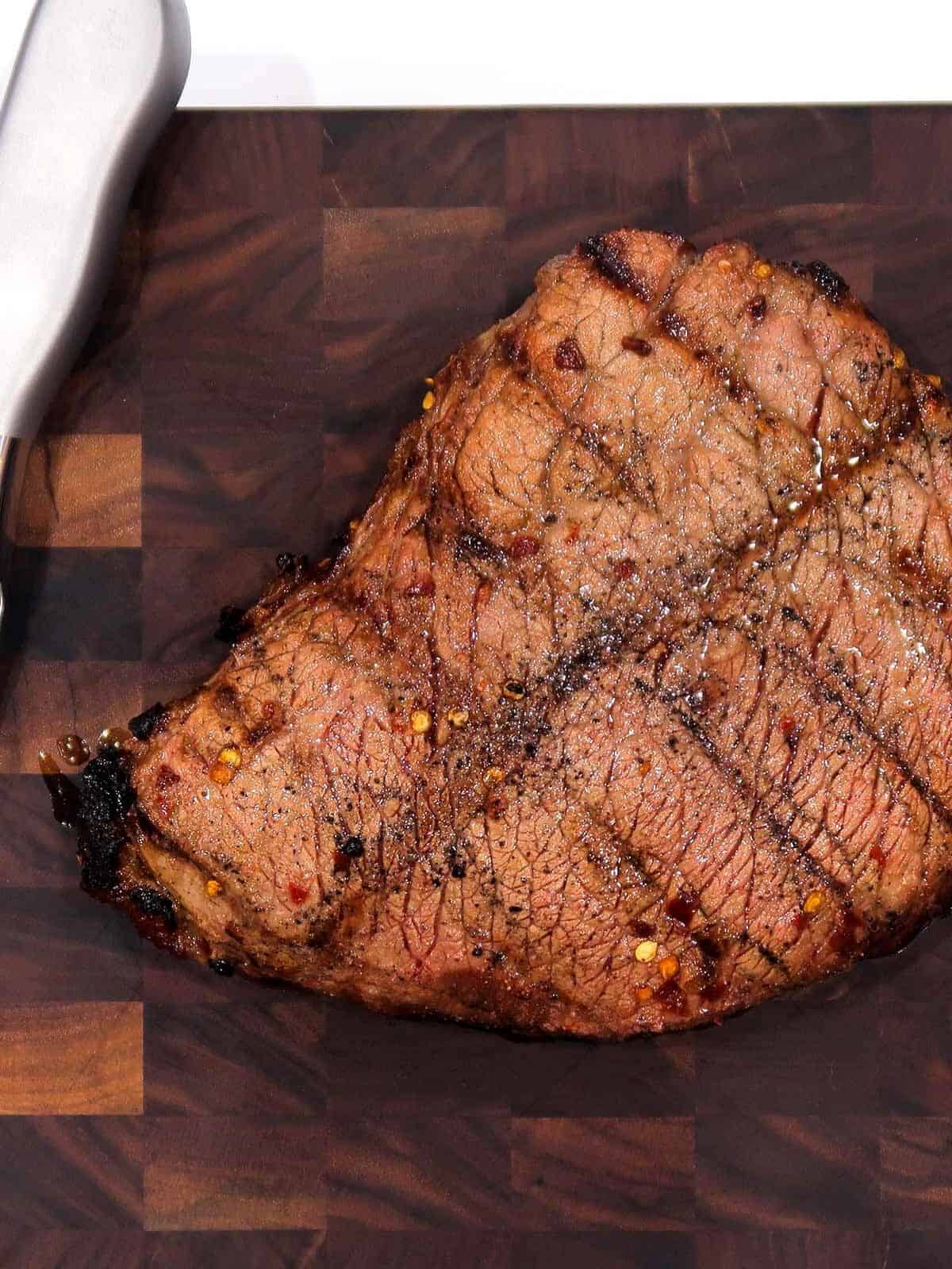 Grilled London broil on a cutting board.
