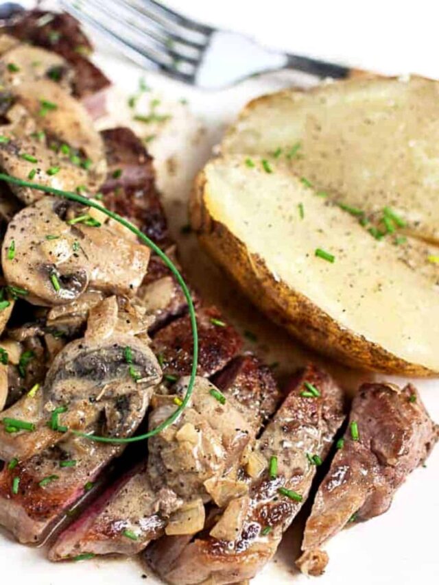 Steak served with potato and topped with chives.