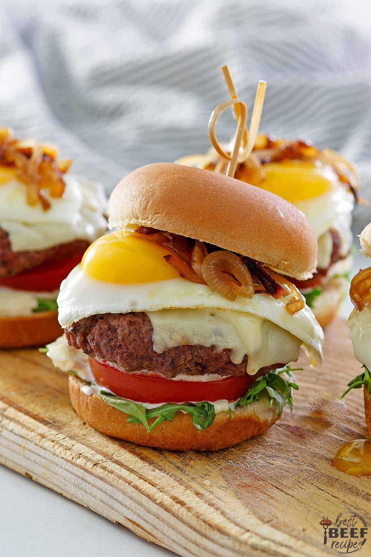 Three egg burgers on a wood surface