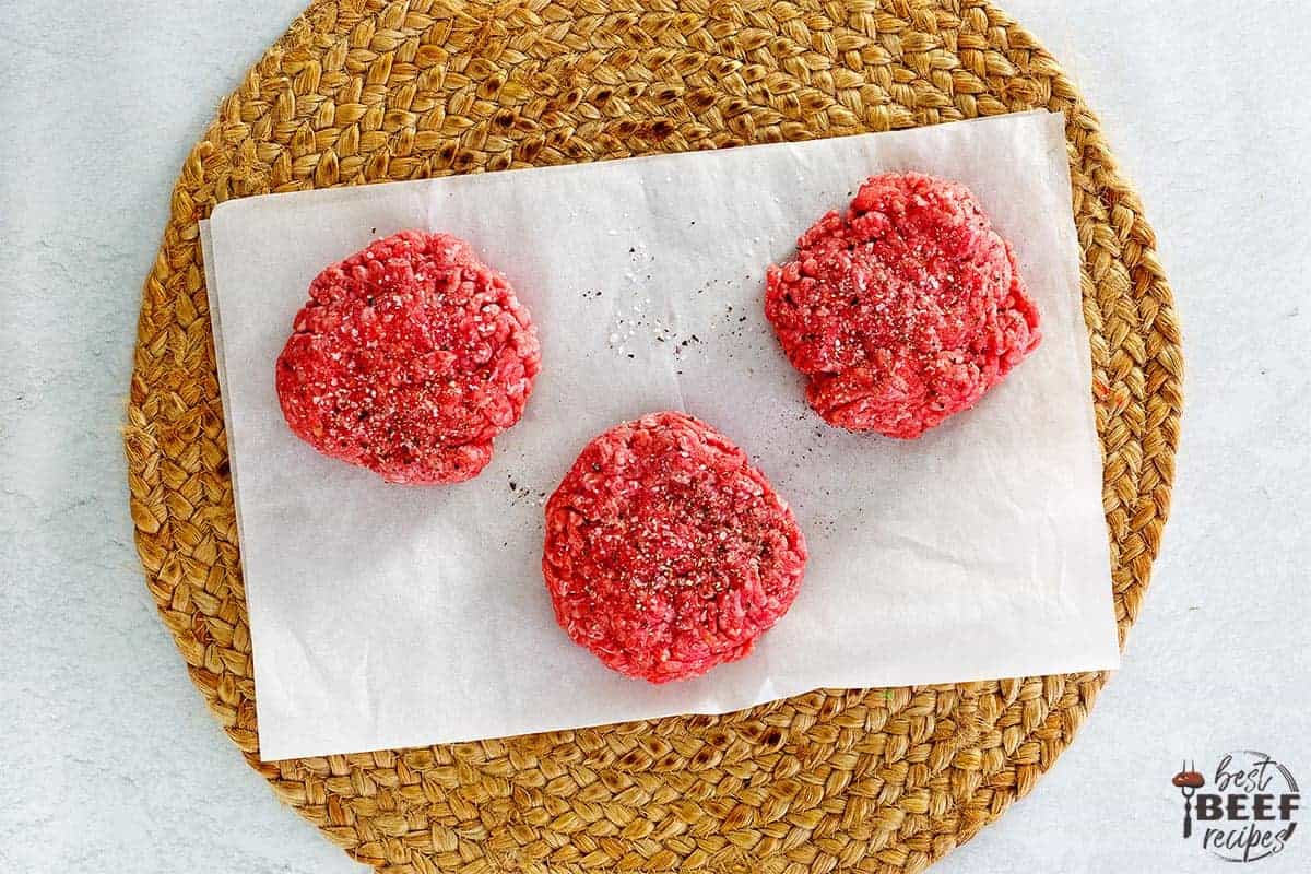 4 burger patties on a white surface