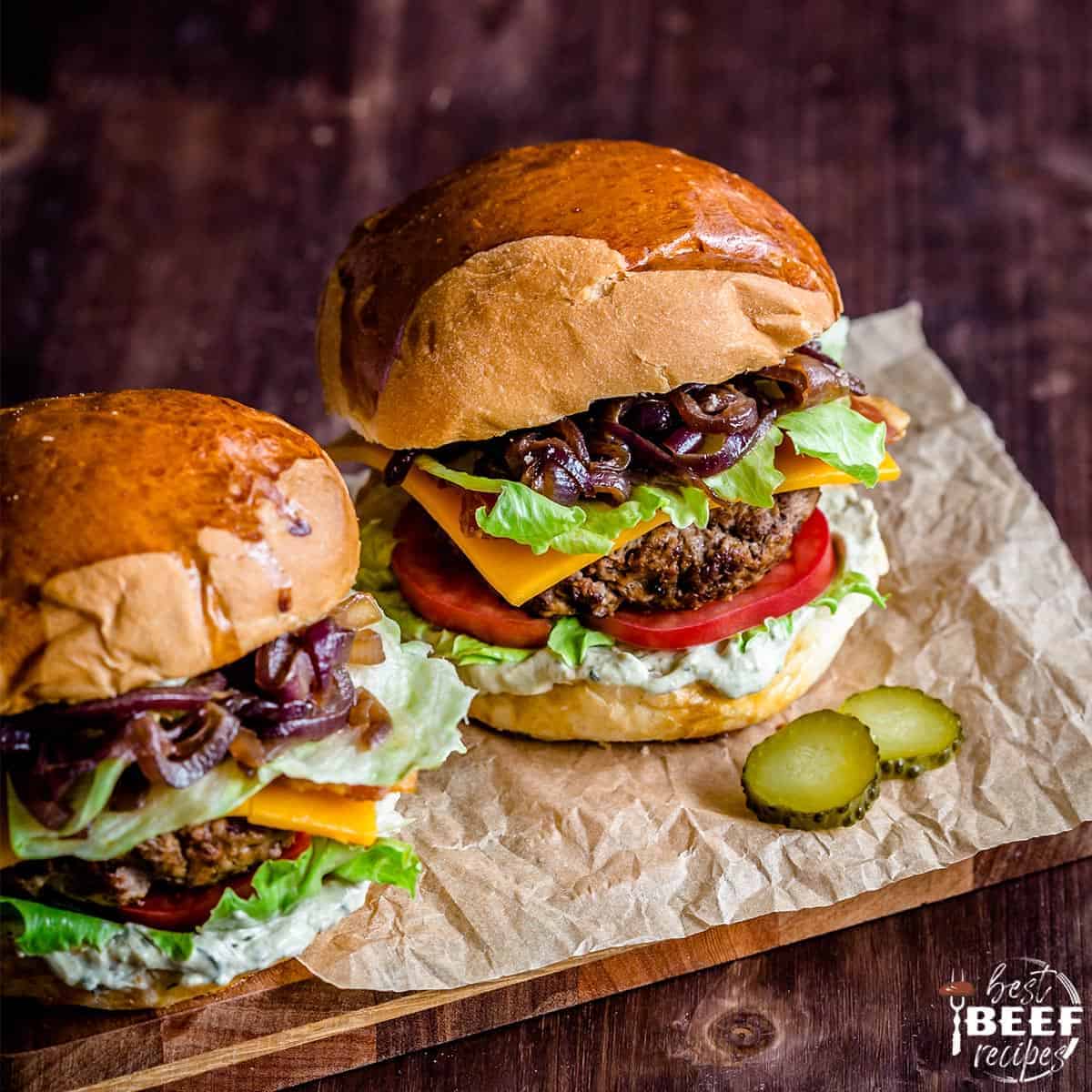 Two loaded burgers on a piece of parchment paper