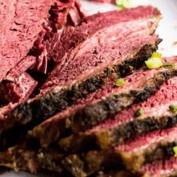 slices of slow cooker beef brisket on a white plate