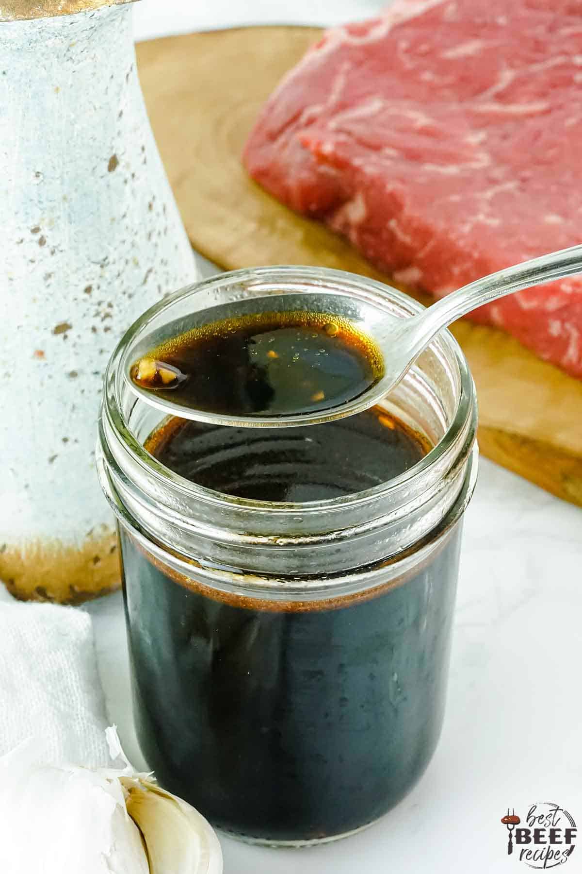 Spoonful of Asian steak marinade over a jar of marinade
