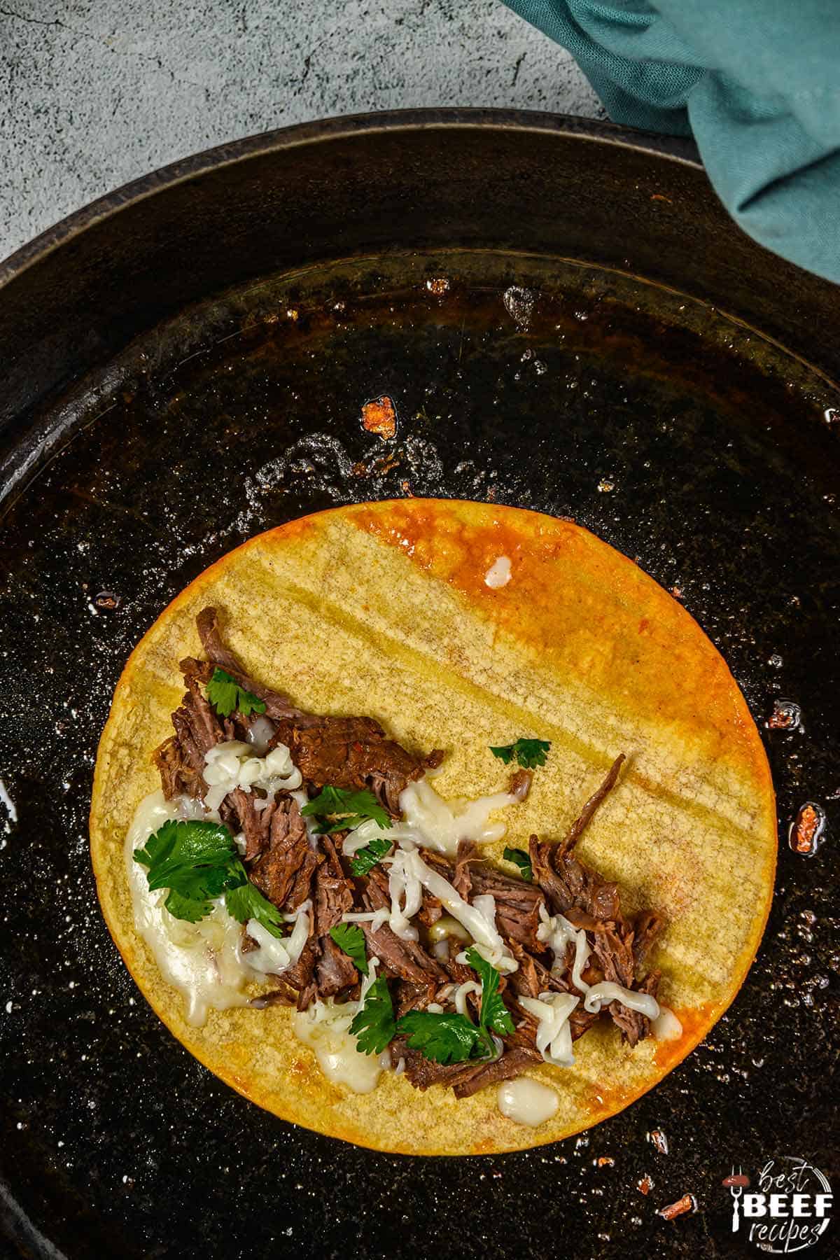 Beef birria tacos in a skillet