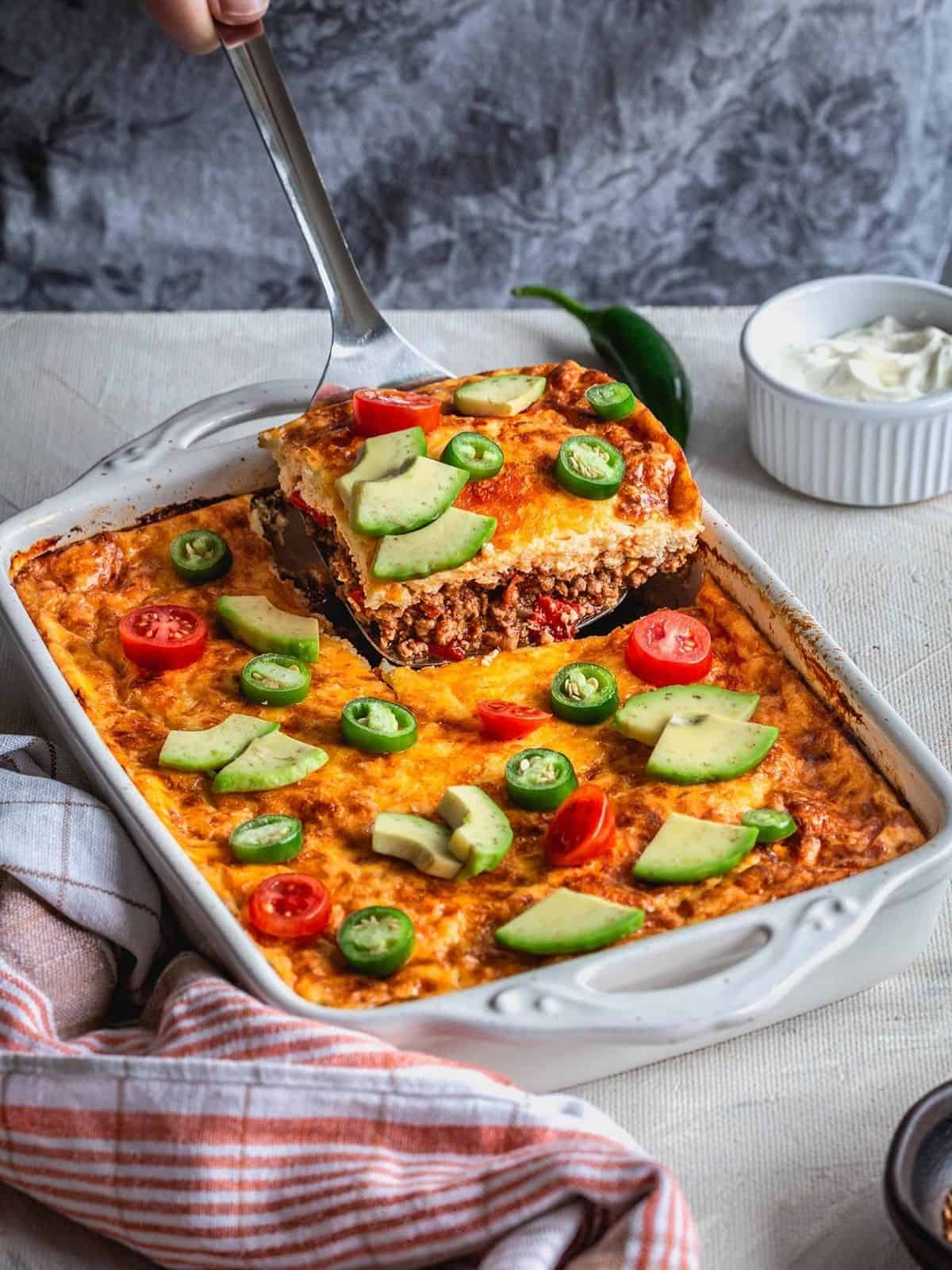 Taco Casserole topped with avocado and peppers.