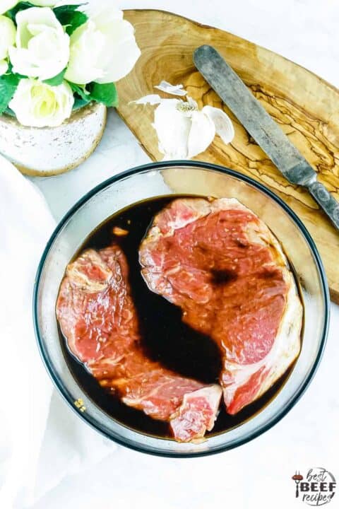 Steak marinating in Asian marinade in a bowl