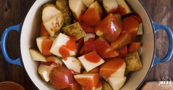 tomato paste on top of vegetables in roast pan
