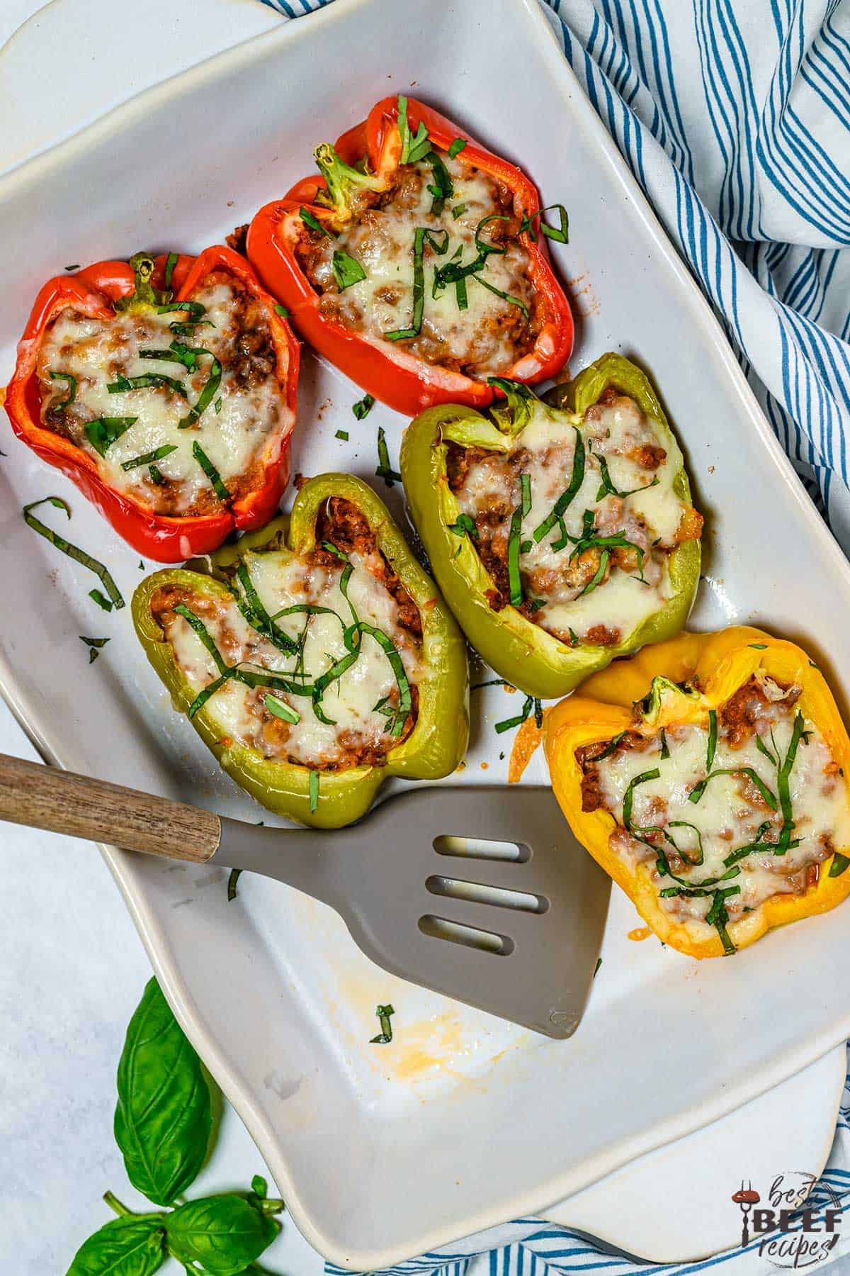 Five stuffed bell peppers on a white platter