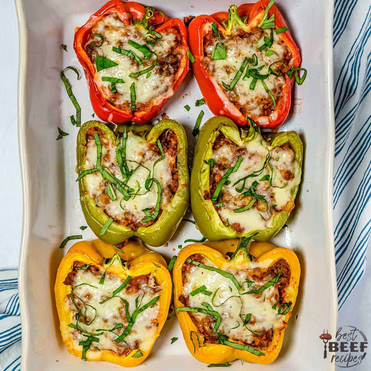 Six stuffed peppers on a white platter