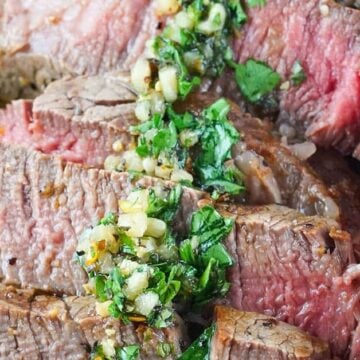 Chimichurri sauce over slices of steak