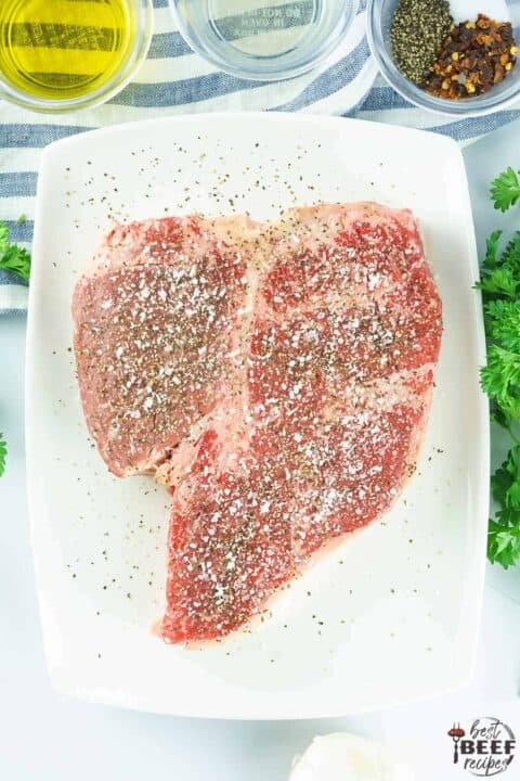 seasoned porterhouse steak on a cutting board
