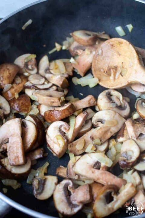 cooking mushrooms and onions for creamy pasta sauce