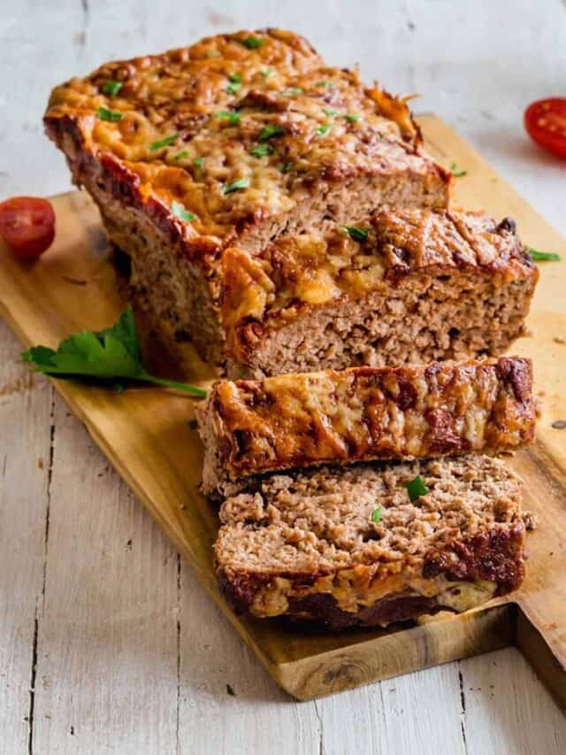 Meatloaf cut into slices on a cutting board.