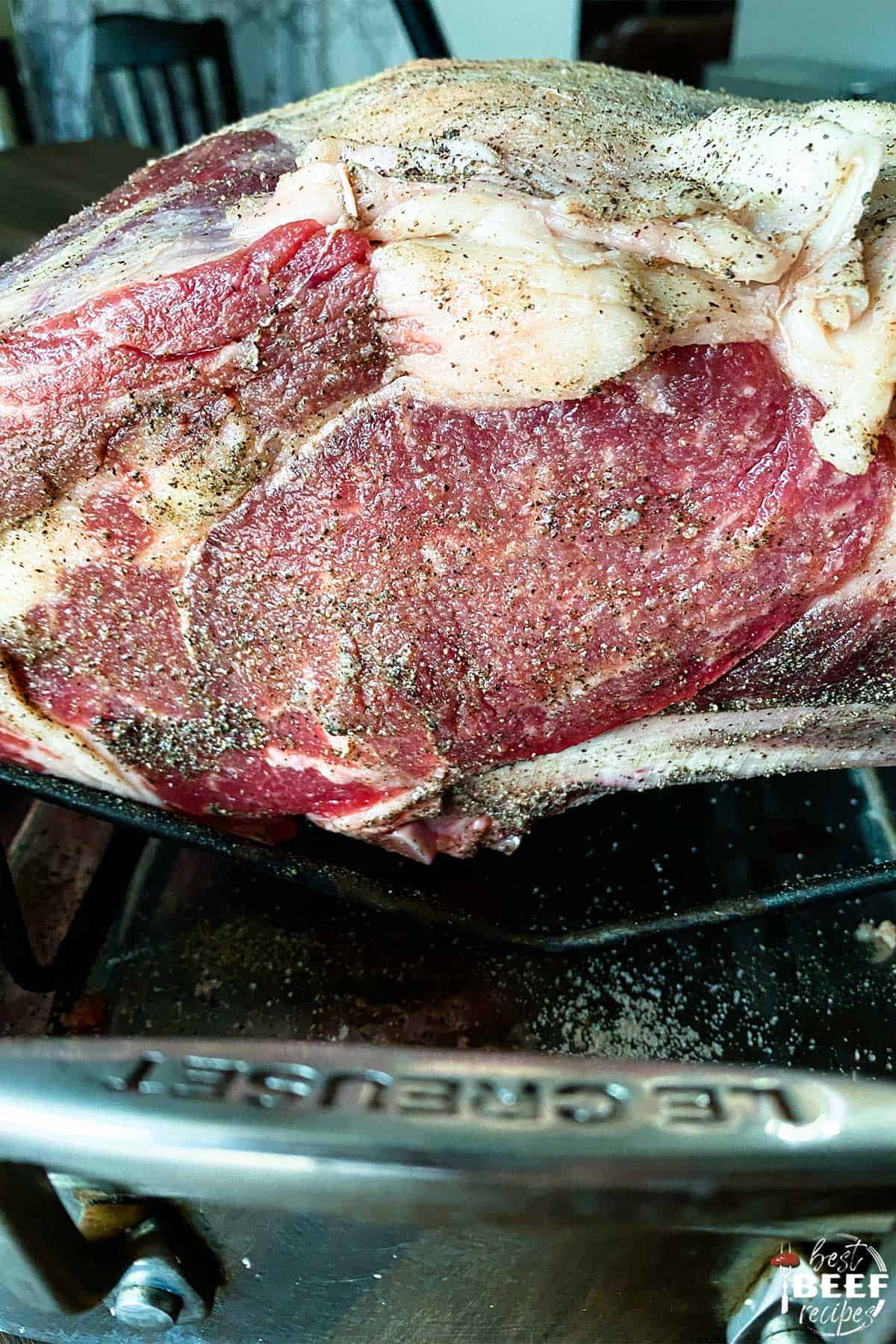 Prime rib seasoned on a roasting rack