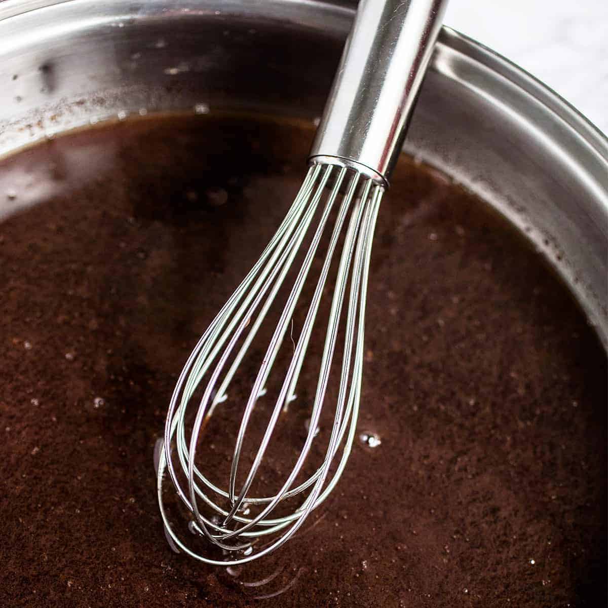 au jus sauce for prime rib in a metal bowl with a whisk