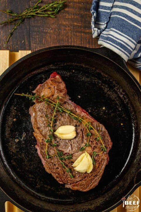 Cooking ribeye steak in a cast iron pan