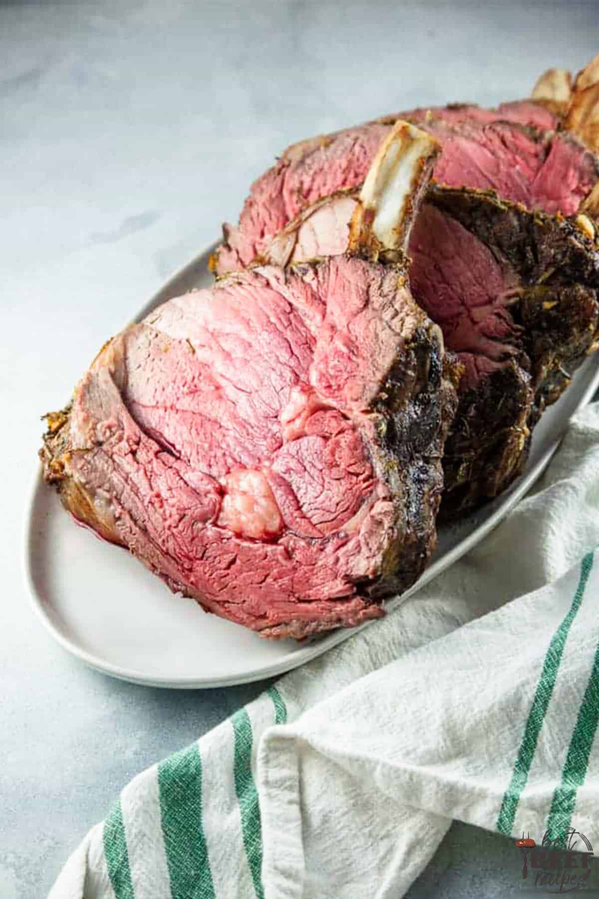 Slices of standing rib roast on a white serving platter
