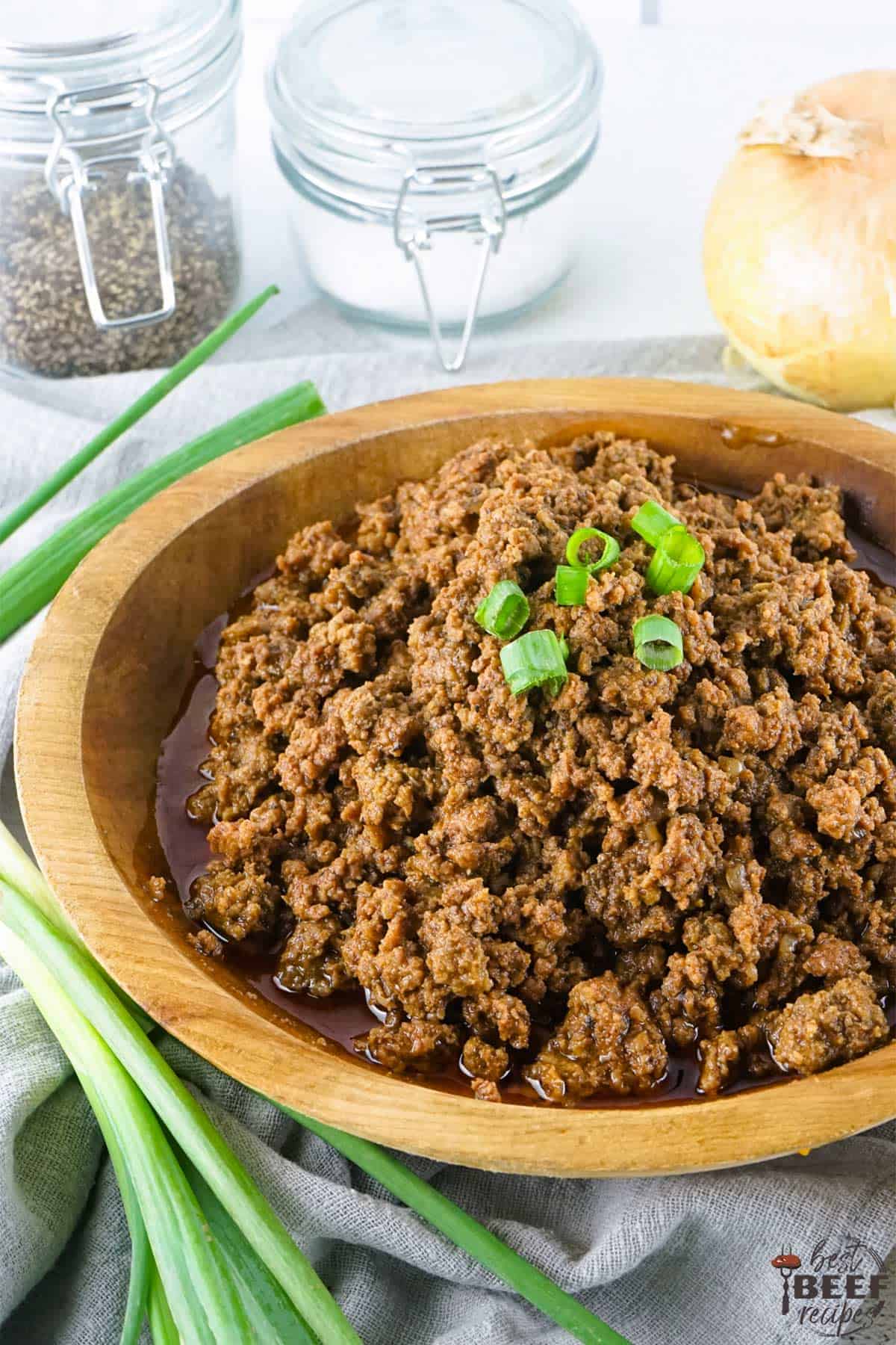 slow cooker taco meat in a bowl near onion