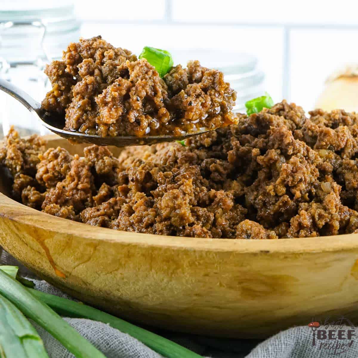 crockpot taco meat in a wooden bowl with a spoon