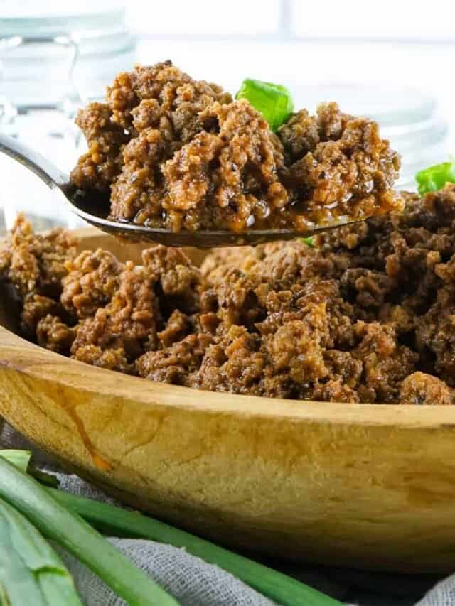 taco meat in a wood bowl with a spoon over top