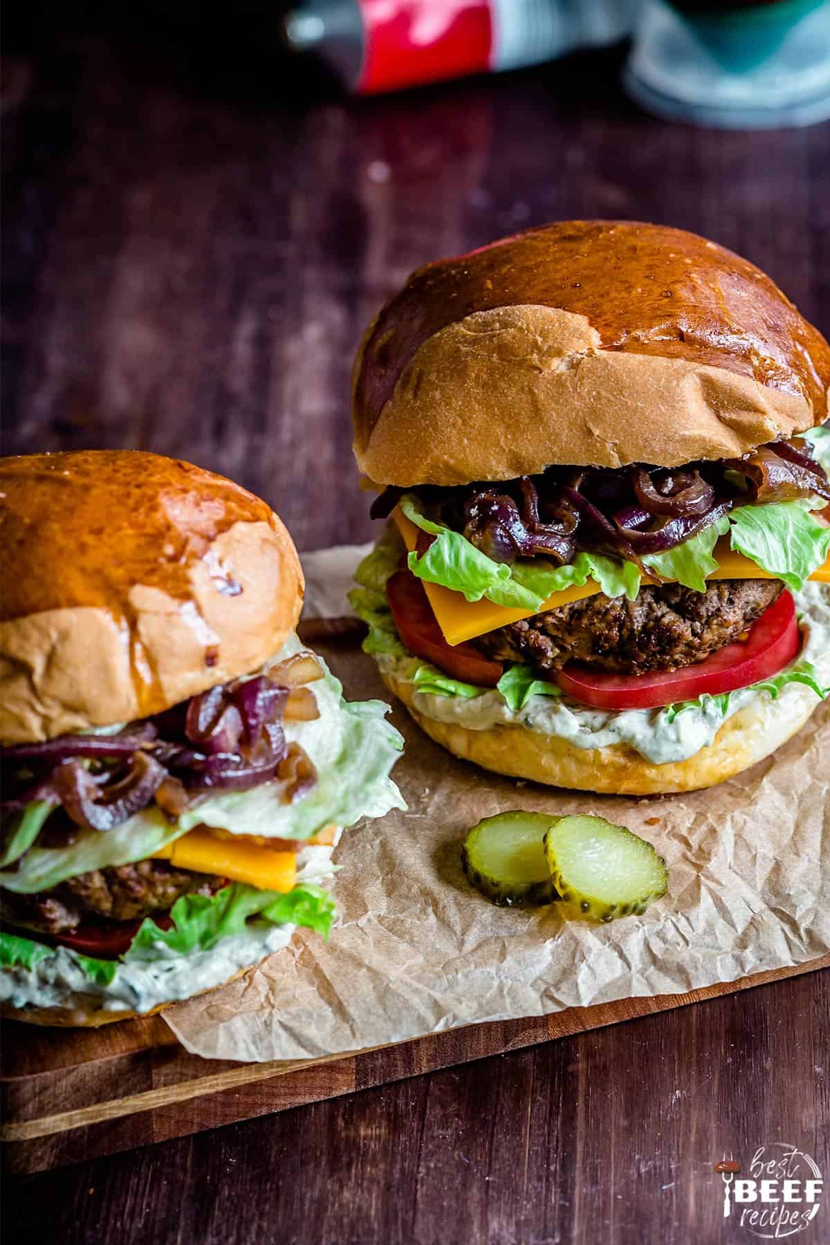 Two loaded burgers on parchment paper