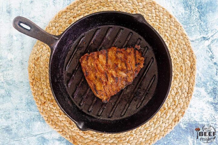 grilling steak in a cast iron skillet