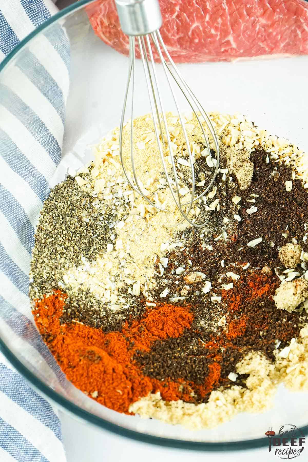 Coffee rub ingredients in a glass bowl with a whisk