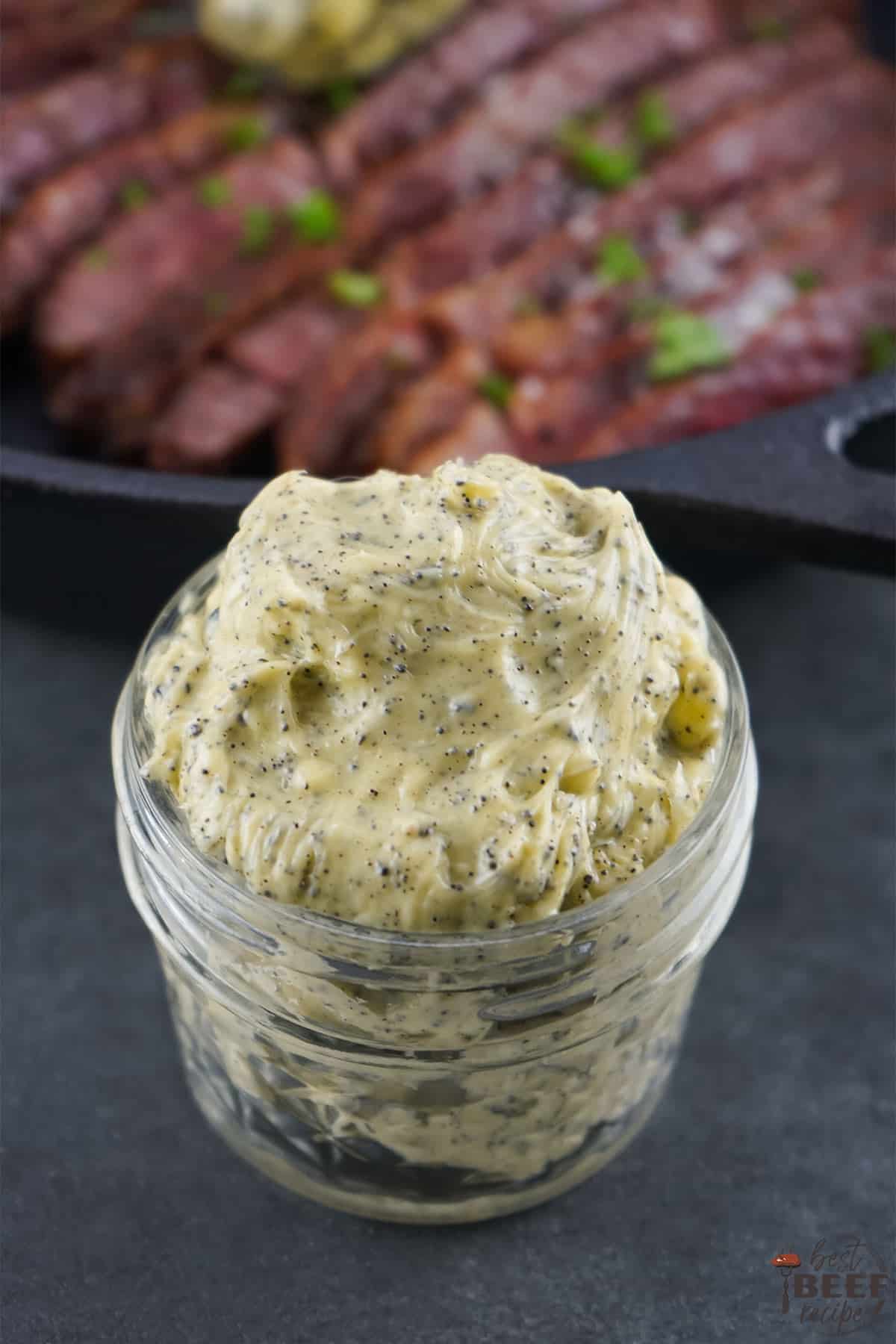 Truffle butter in a glass container by sliced wagyu steak