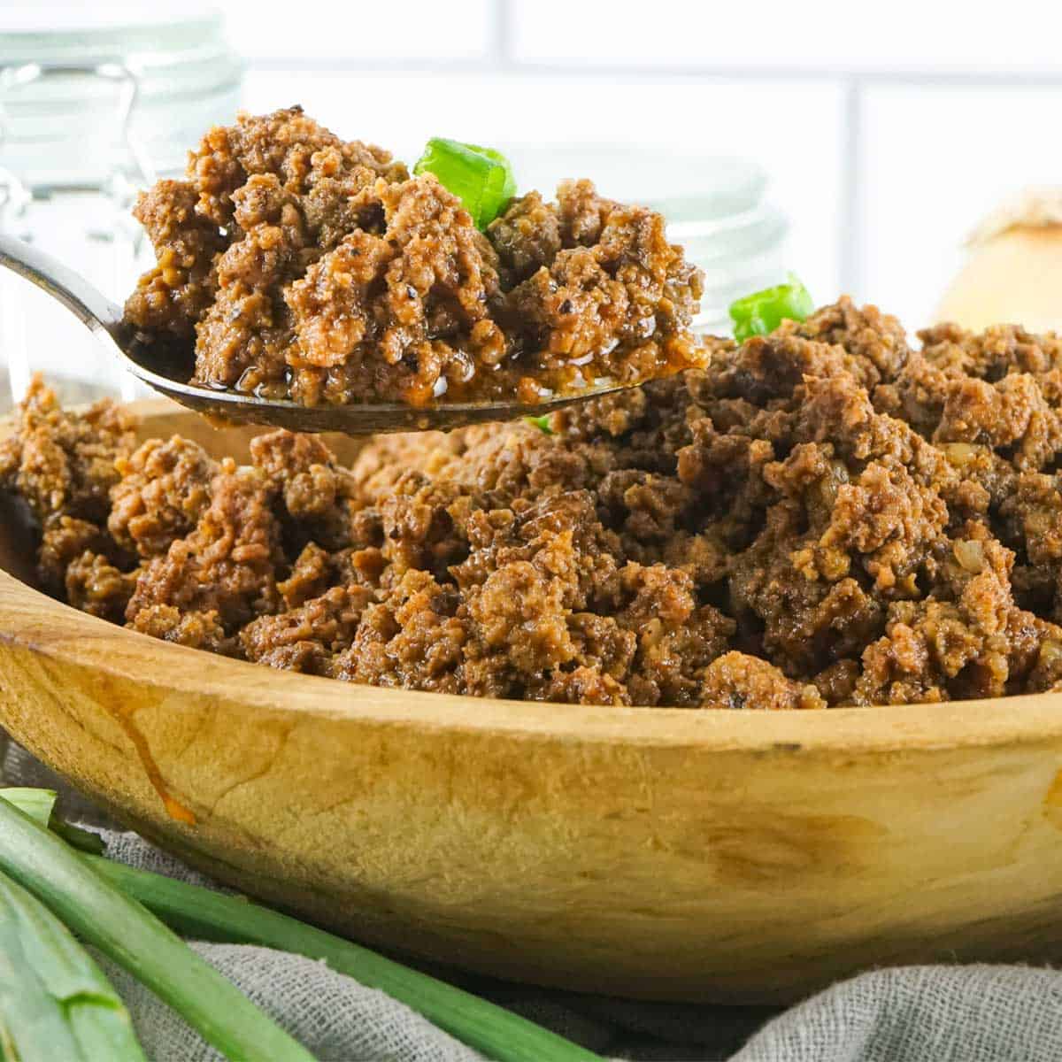 seasoned taco meat in a bowl with a spoon