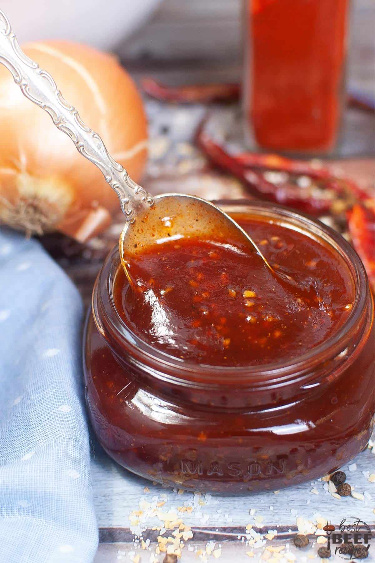 a spoonful of bbq sauce in a jar