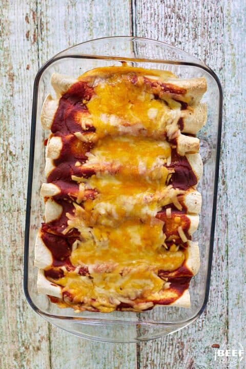 beef enchiladas layered in a clear dish