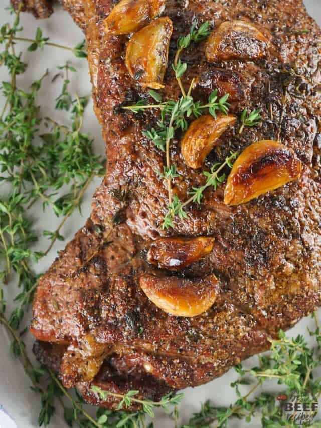 tri tip on a plate with garlic and herbs