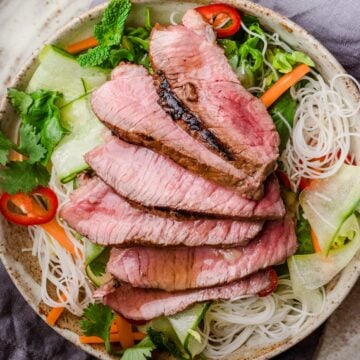 sirloin steak sliced on top of a vietnamese salad