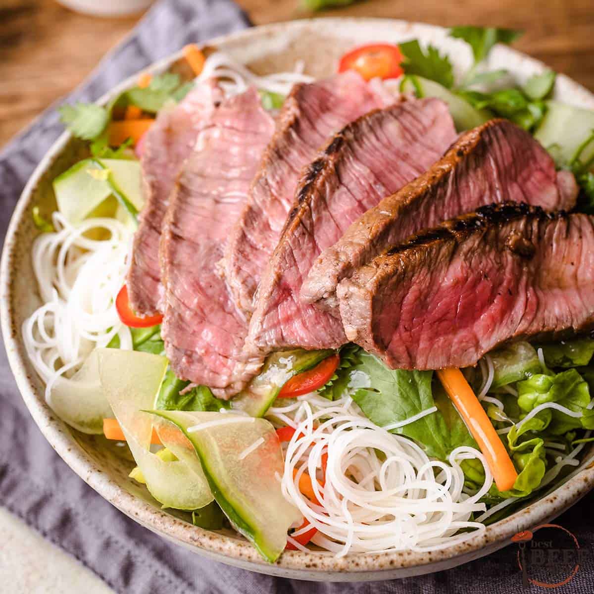 sirloin steak sliced on top of a vietnamese salad