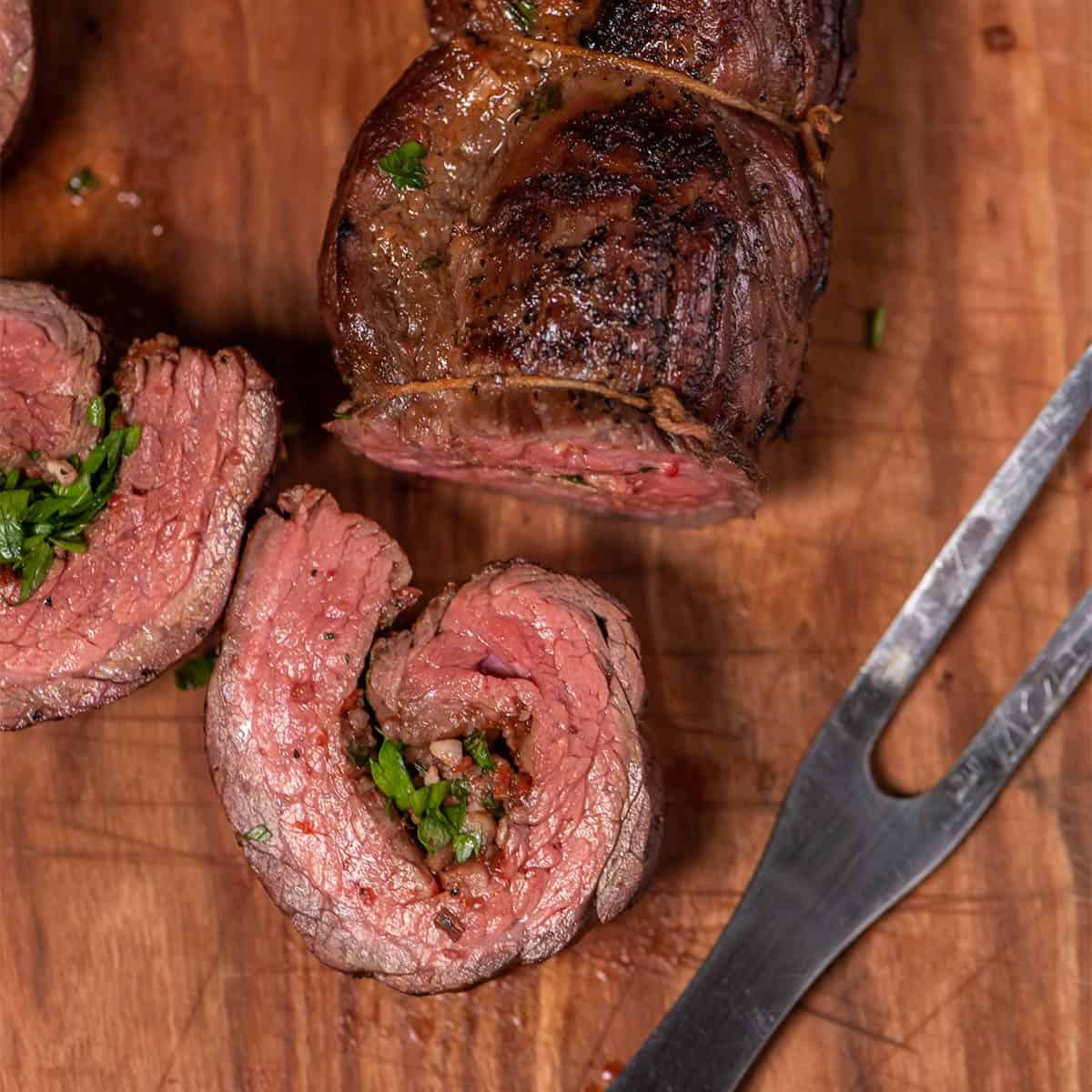 stuffed flank steak sliced up close with a steak fork