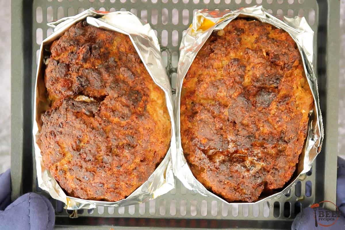 two air fried meatloaves wrapped in foil on a tray