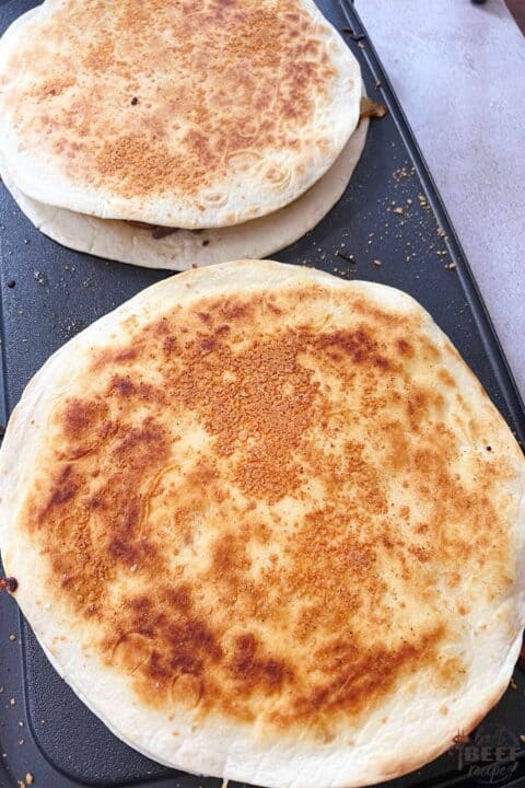 browned quesadillas on a griddle