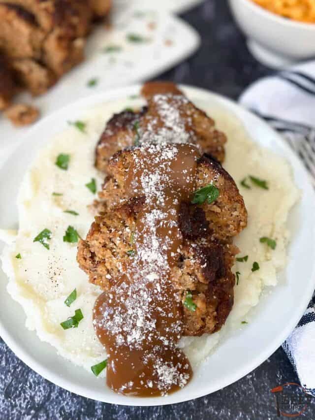air fryer meatloaf with gravy and parmesan cheese over a bed of mashed potatoes