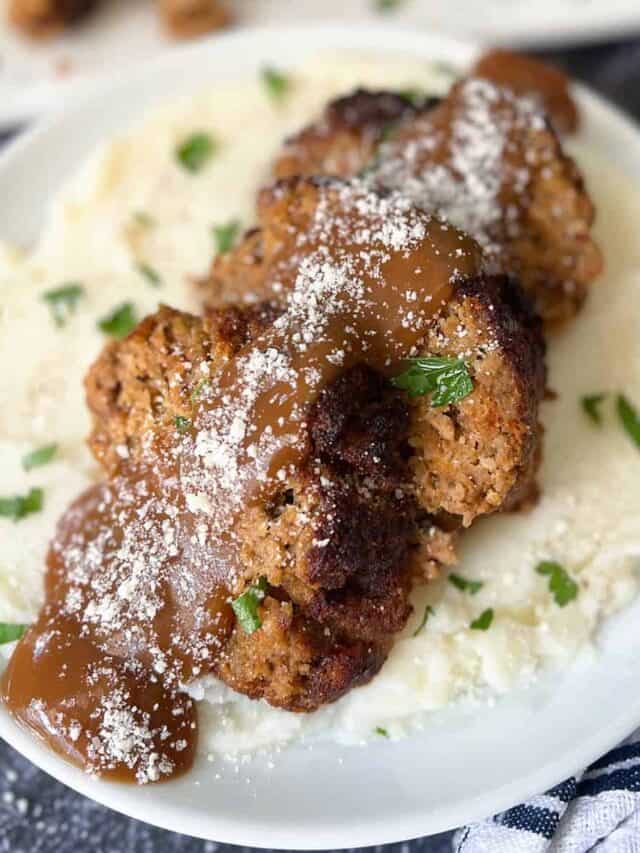 three slices of air fried meatloaf over mashed potatoes covered in gravy