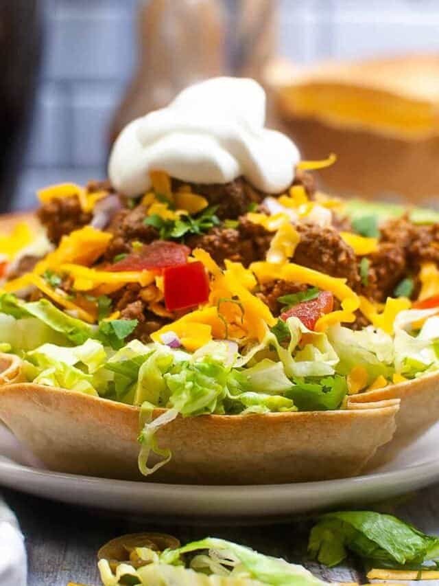 taco salad in a tortilla bowl on a white plate