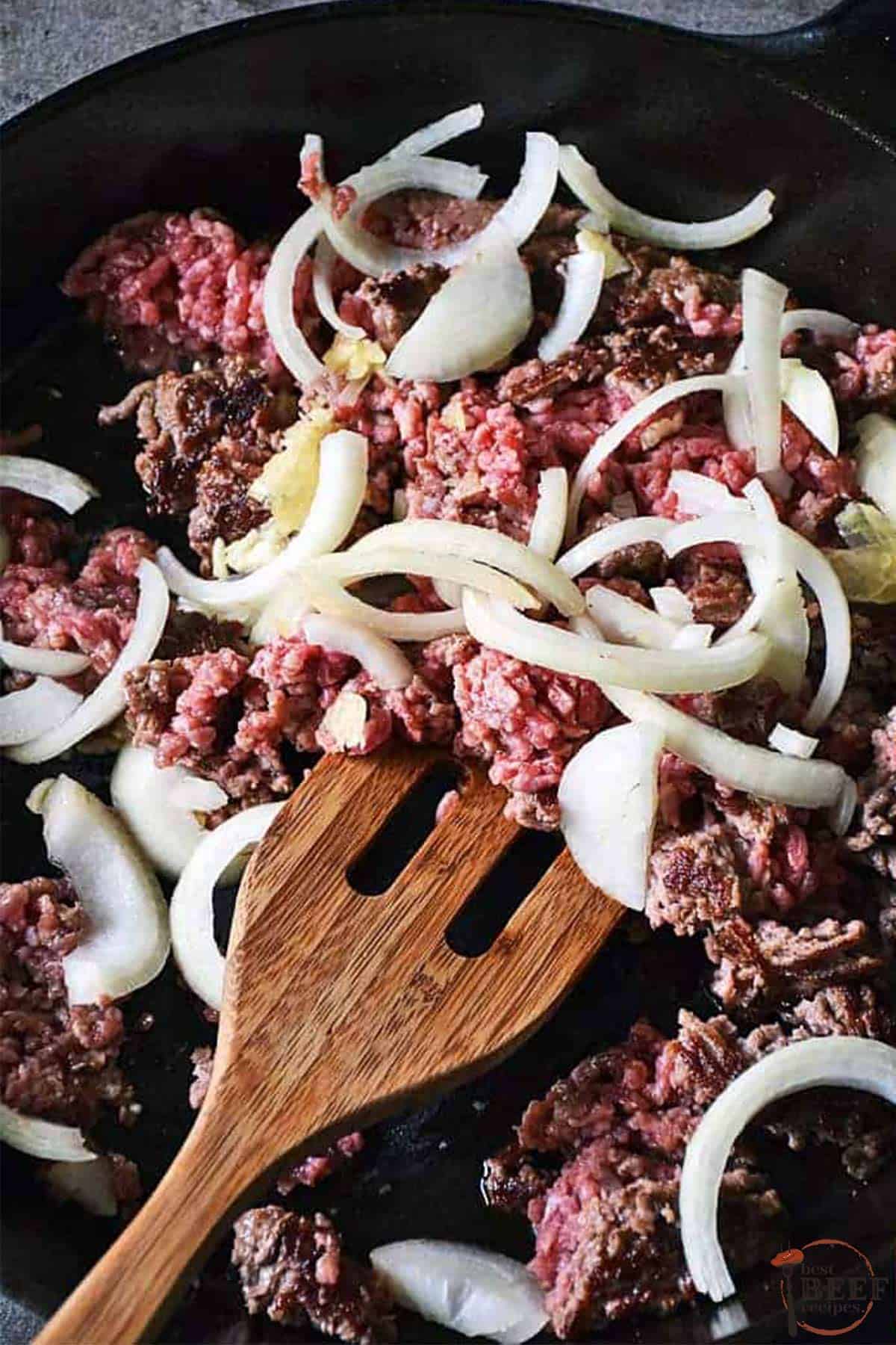 breaking apart ground beef with onions