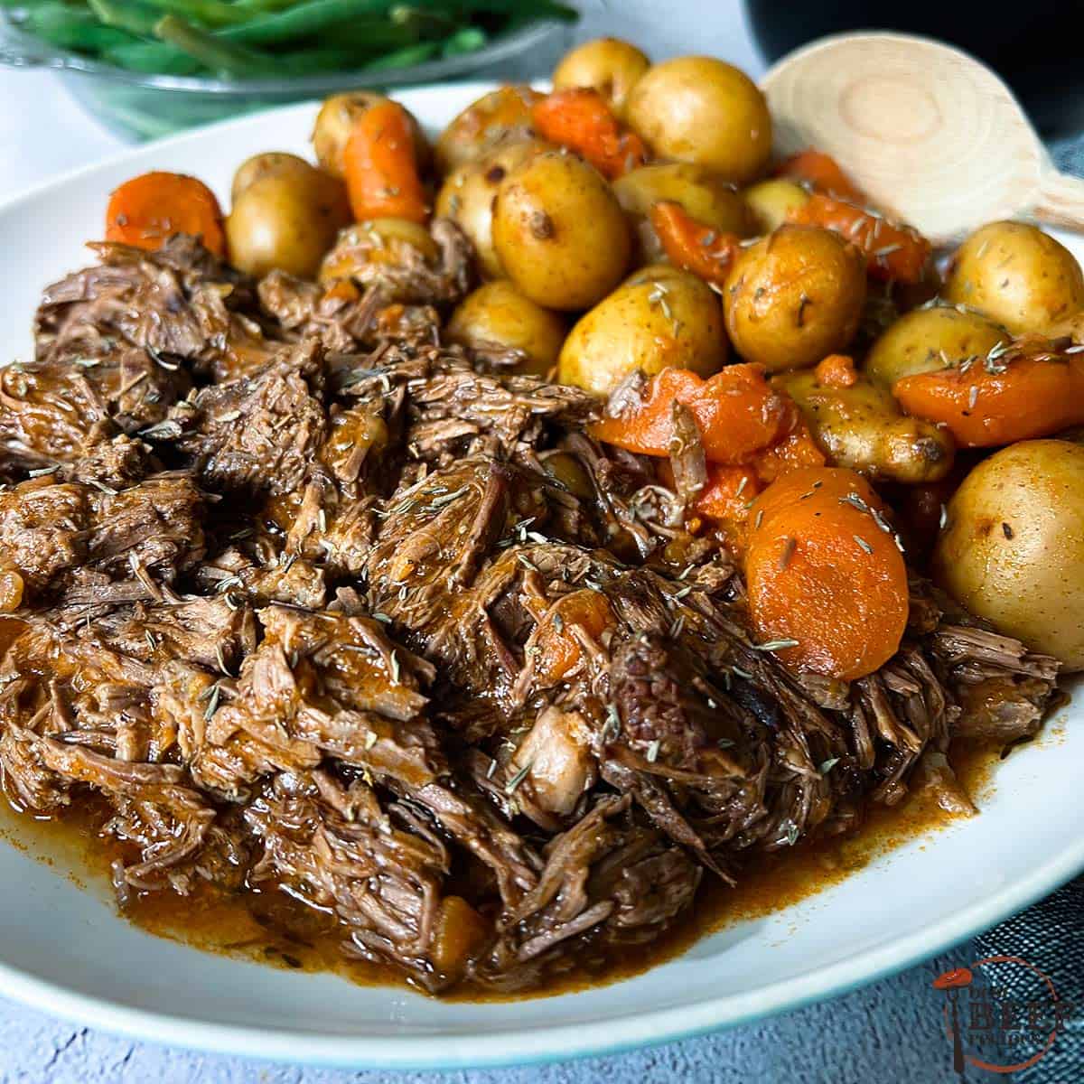 instant pot pot roast with gravy, potatoes, and carrots on a plate